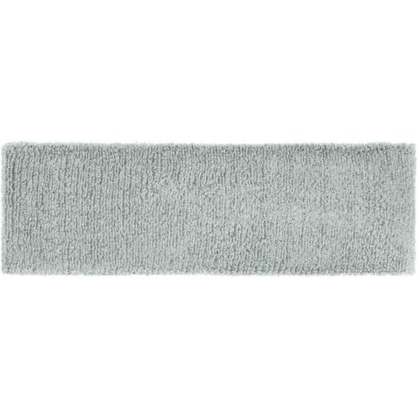 A soft grey Terry headband with a plush texture, featuring a branding logo.