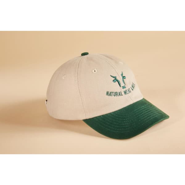 A beige cap with a green peak and a logo on the front, featuring a six-panel design.