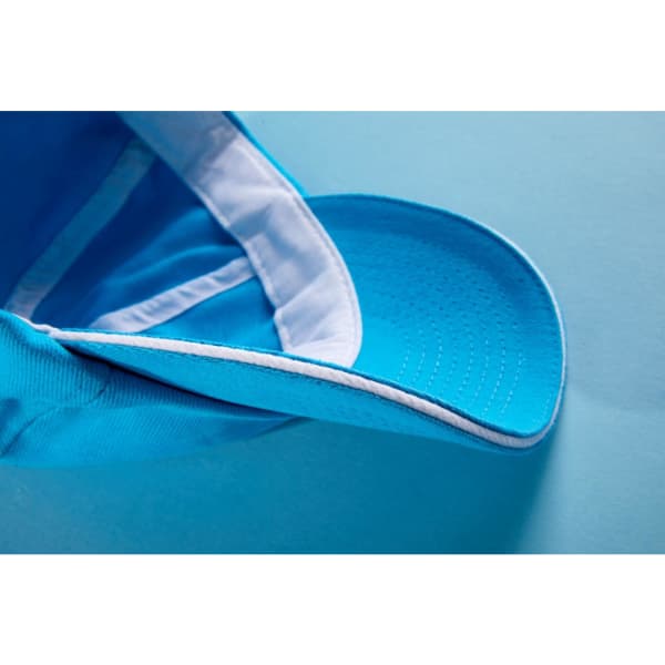 A blue 6 Panel Raver Sandwich Cap featuring a curved brim and a white and blue interior, with a logo present.