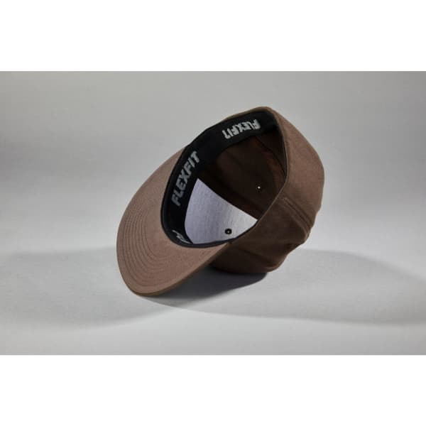 A brown Flexfit® Flat Peak Cap displayed sideways, featuring a logo on the interior.