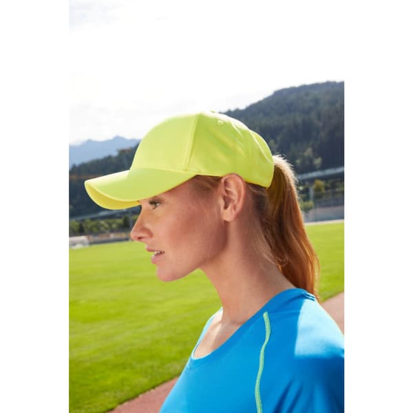 A bright yellow 6 panel sport mesh cap is worn by a woman with a ponytail, set against a grassy field backdrop.