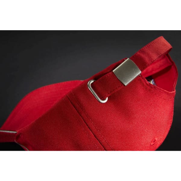 A red 6-panel cap with an adjustable strap and metal buckle at the back, featuring a logo.