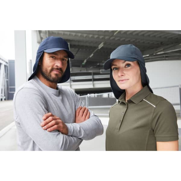 A navy blue six-panel cap with a neck guard, worn by a man and a woman in casual attire.