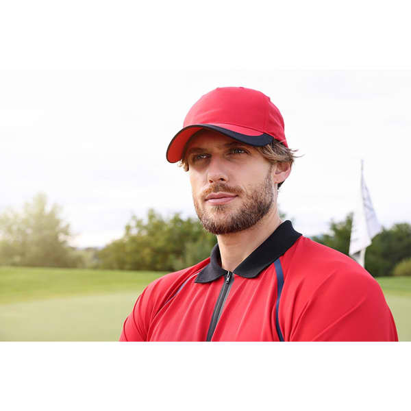 A red 5 panel sports cap positioned on a model outdoors near a golf course. The cap features a logo on the front.