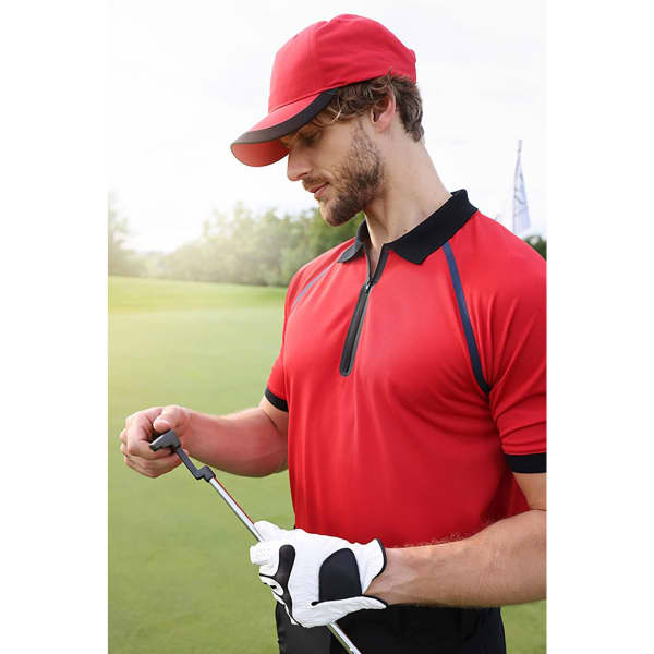 A red 5 panel sports cap worn by a man in a red polo shirt, holding a golf club on a green. The cap features a logo.