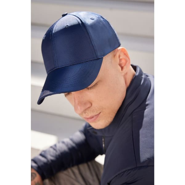 A navy blue 6 panel cap is worn by a person, showcasing its sleek design and fitted structure.