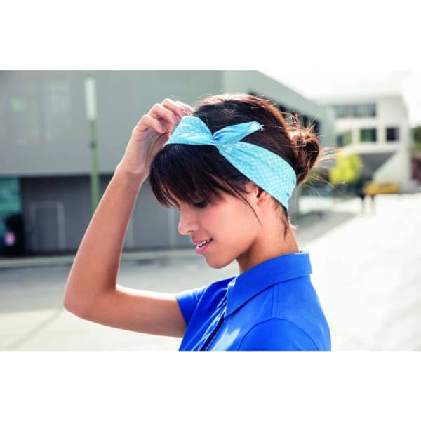 A woman wearing a light blue bandana styled as a headband, showcasing a tied bow.