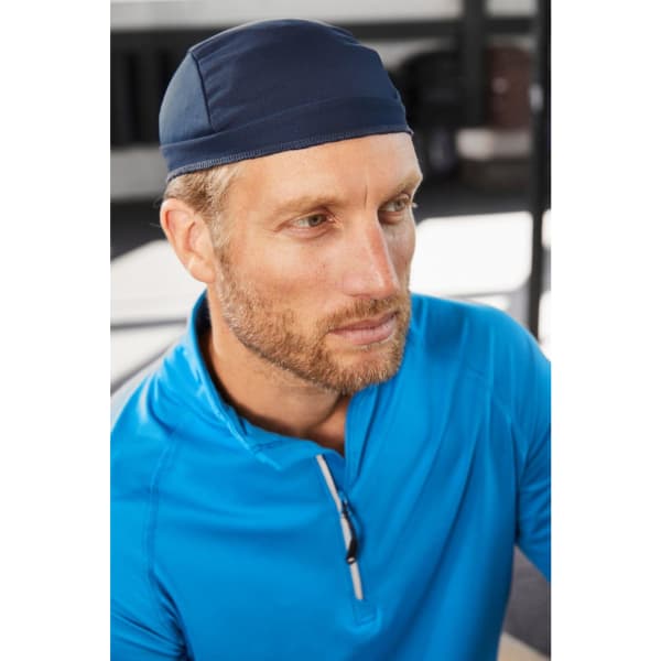 A navy blue bandana hat made of functional fabric, worn by a man in a blue top, featuring a logo.