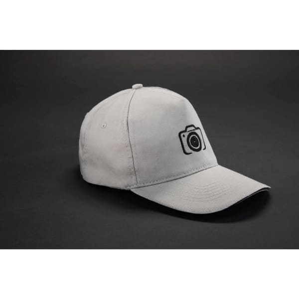 A grey 5 Panel Promo Sandwich Cap with a camera logo on the front, set against a dark background.