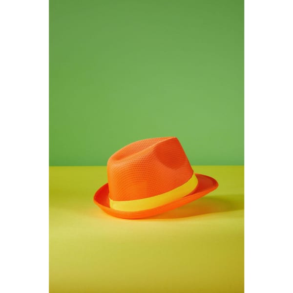 An orange hat with a yellow band, resting on a green and yellow background. It has a mesh design.