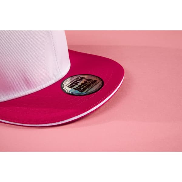 A pink and white trucker cap featuring a circular logo on the brim.