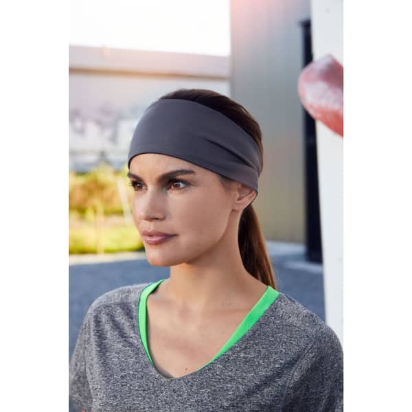 A running headband in grey worn by a woman with long brown hair, paired with a grey athletic top.