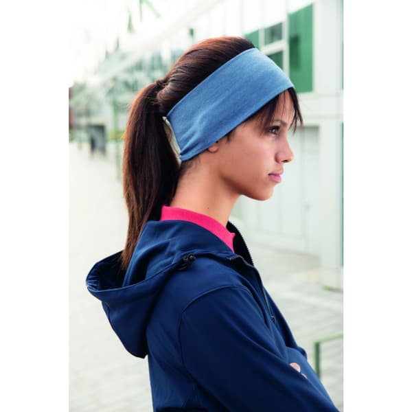 A blue bio cotton headband worn by a woman with long hair, set against an outdoor backdrop.