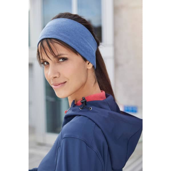A blue bio cotton headband worn by a woman with brown hair, set against an outdoor background.