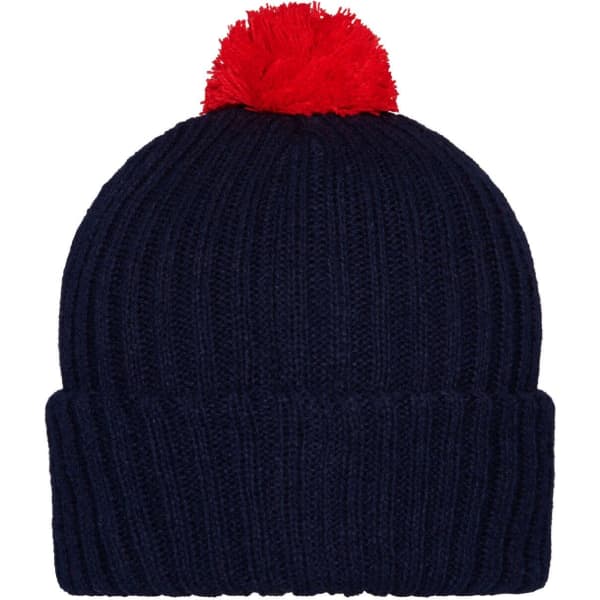 A knitted beanie in navy blue with a red pompon on top, featuring a ribbed design.