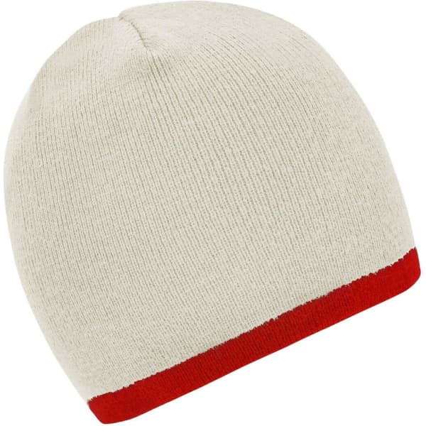 A beanie in cream with a contrasting red edge, featuring a subtle texture. It has a logo on one side.