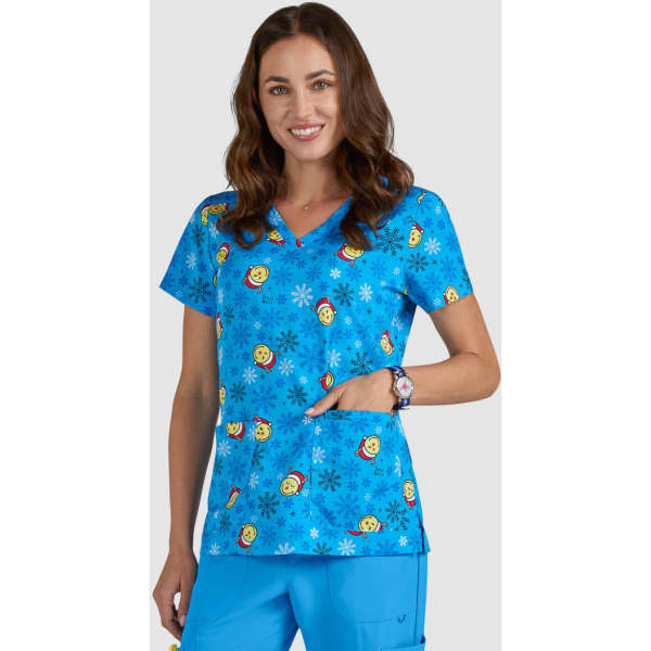 A blue scrub top with colorful smiley faces and floral patterns, featuring a pocket and a logo.