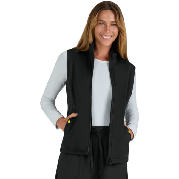 A black fleece vest with a zip front and pockets, worn by a smiling woman with long, wavy hair.