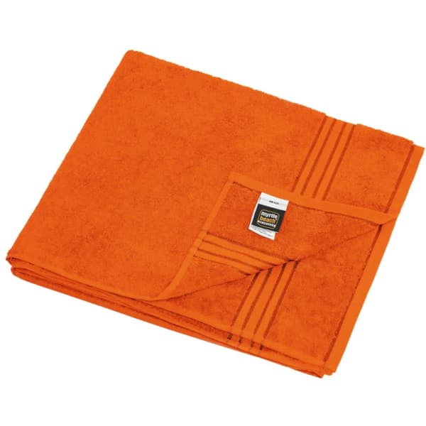 An orange sauna sheet folded neatly, featuring a textured surface and a branding label on one corner.