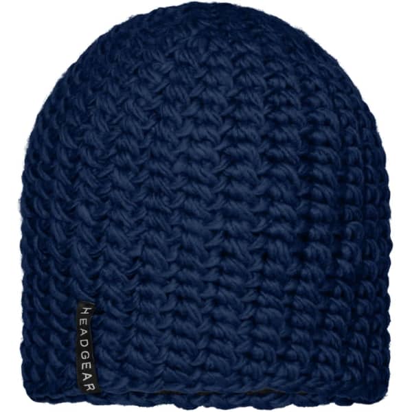 A navy crocheted beanie with a textured finish and a discreet logo tag on the side.