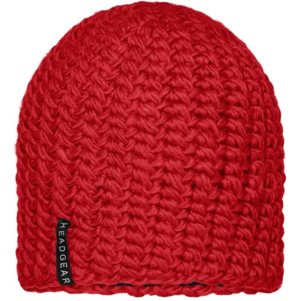A red crocheted cap with a knitted texture and a small logo tag on the side.