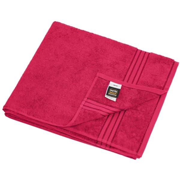 A pink sauna sheet folded neatly, with a striped design and a label on the corner.