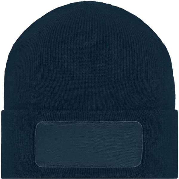 A knitted beanie in dark blue featuring a blank patch for custom branding.