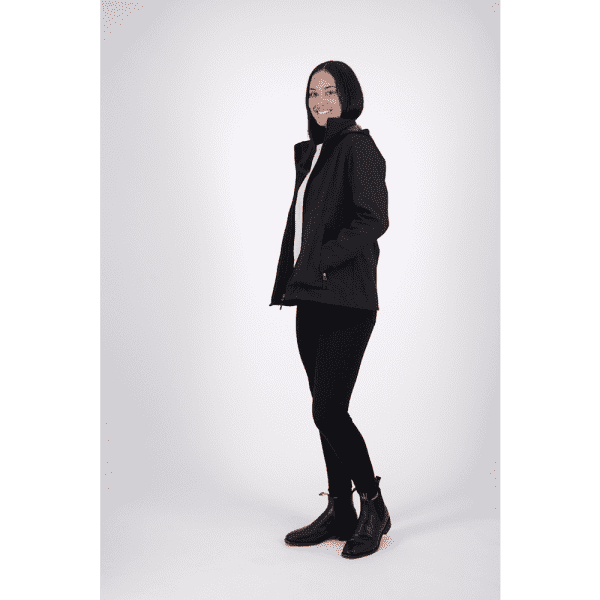 A black softshell jacket worn by a woman, featuring a zip-up front and two side pockets.