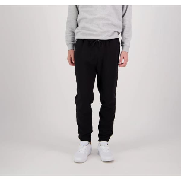 Lounge Warrior Pants in black with an elastic waistband and cuffed ankles, paired with a grey sweatshirt and white shoes.