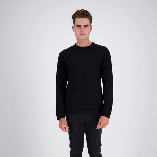 A black long-sleeve sweater worn by a model standing against a light background, featuring a logo.