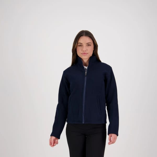 A woman wearing a navy microfleece jacket with a zip-up front and side pockets. The jacket has a logo.