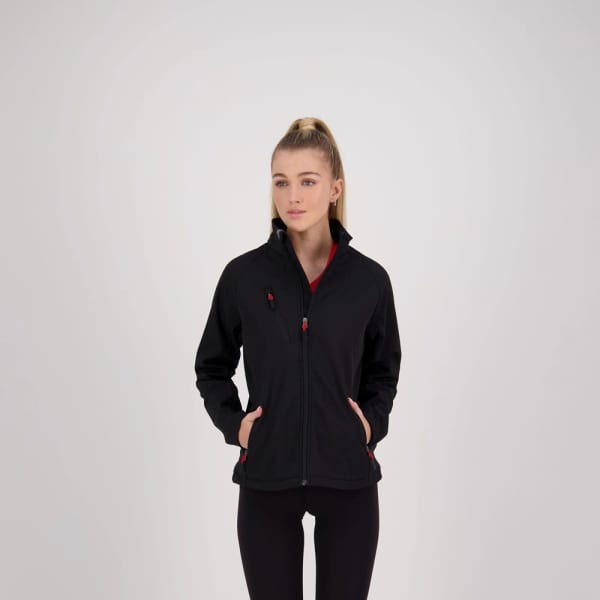 A soft shell jacket in black with red contrast zip pulls and pockets, worn by a model against a neutral background.