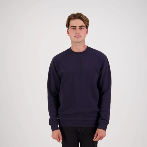 A navy blue jumper with a crew neckline, featuring a logo on the front. The model stands against a plain background.