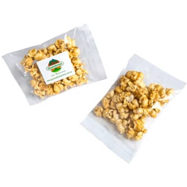 A clear bag containing caramel popcorn, featuring a small logo on the packaging. The popcorn is golden yellow.