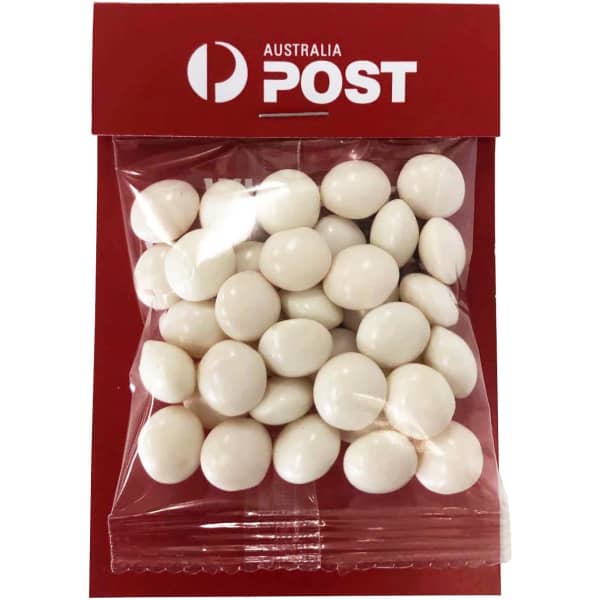 A clear bag containing white chewy mint candies, packaged with a red backing and featuring a logo.