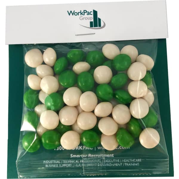 A sealed bag of chewy fruit balls in green and white, featuring a logo on the packaging.