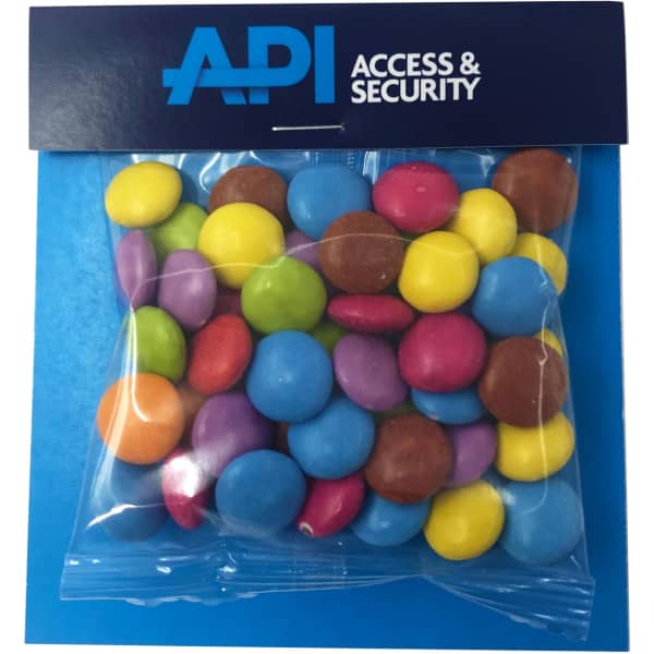 A clear bag filled with colourful Smarties in various shades, featuring a branded header.