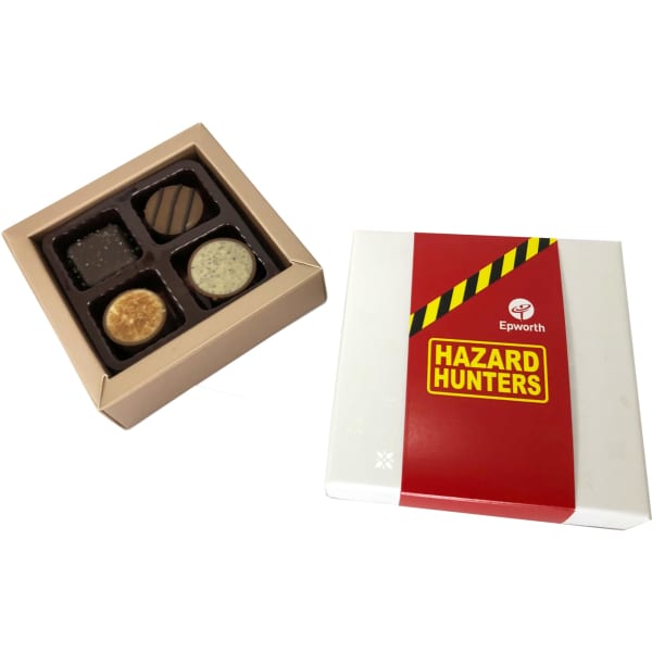 A chocolate box with a white and red exterior containing four assorted chocolates in a gold tray inside.