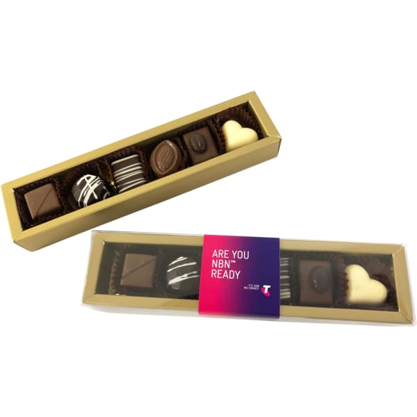 A gold box containing assorted pralines, including dark, milk, and white chocolates, with decorative patterns.