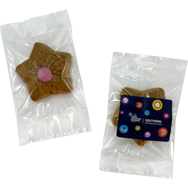 A star-shaped shortbread biscuit in a clear wrapper, featuring a pink centre, accompanied by a branded label.