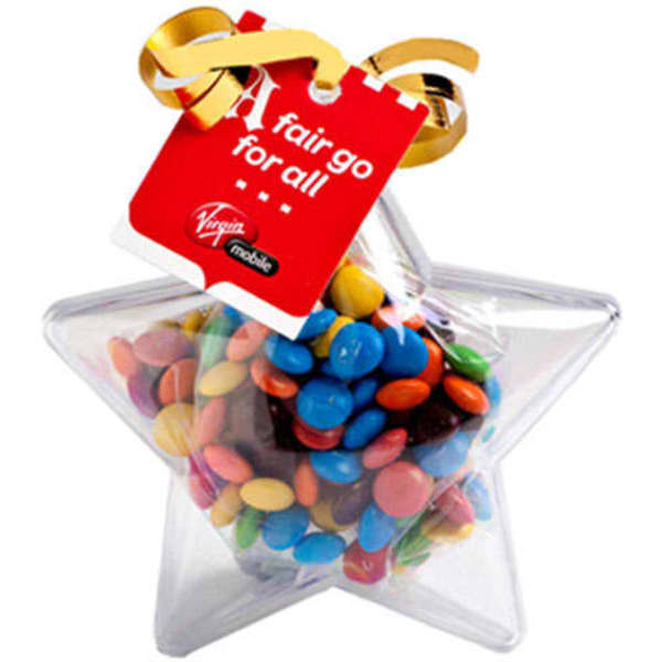 A clear acrylic star filled with colourful M&Ms, topped with a ribbon and a tag.