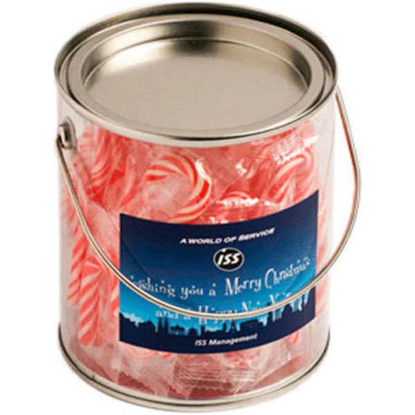 A metallic bucket filled with red and white striped candy canes, featuring a branding label. 