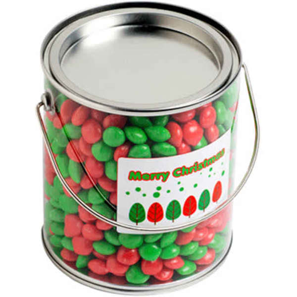 A metal bucket filled with red and green chewy fruit candies. It features a festive label with trees.