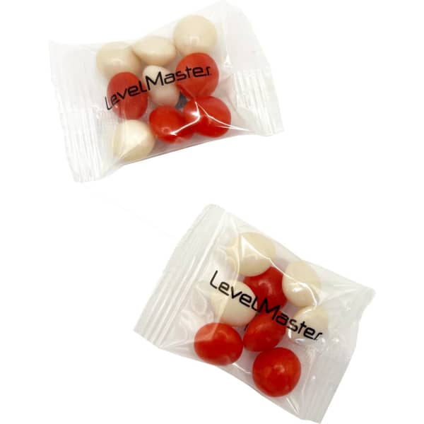 A clear packet containing red and white chewy fruit-flavoured candies, with a logo on the packaging.