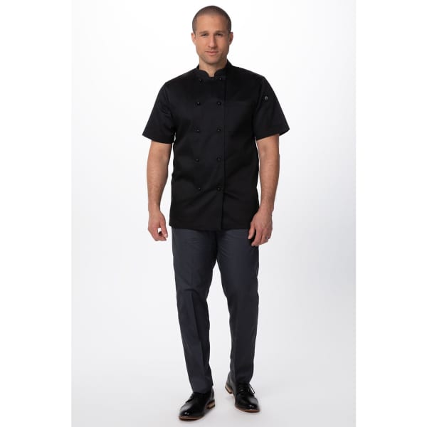 A black men's chef jacket featuring short sleeves, paired with dark trousers, on a male model with a neutral background.