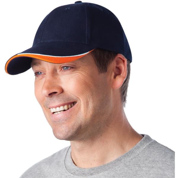 A navy blue cap with an orange accent, featuring a logo, being worn by a smiling man.