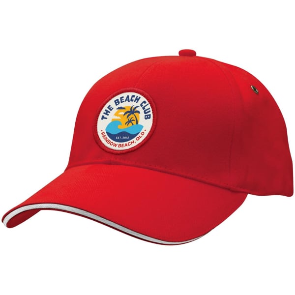 A red cap featuring a round patch with a beach design and a logo, accented with white trim.