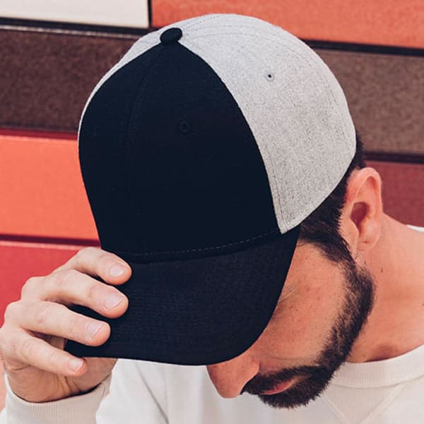 A cap featuring a black front and grey back, with a curved brim and a logo on the side.