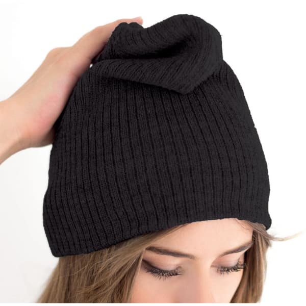 A black beanie with a unique fold at the top, held by a person's hand. It features a logo.