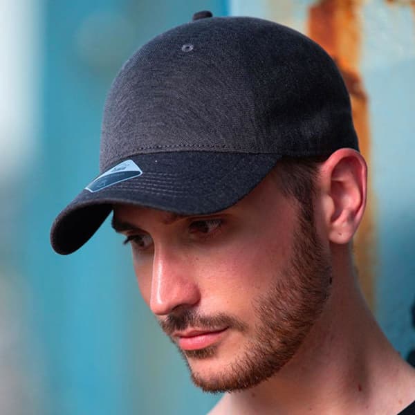 A dark grey cap with a curved brim and a logo on the front, worn by a male model.